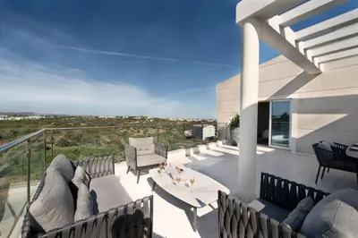 a balcony with a couch and a table and chairs at Penthouse Monte da Eira - Sunset in Albufeira