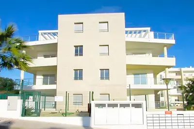 a white apartment building with a white garage at T1 Albufeira Tranquilidade in Albufeira