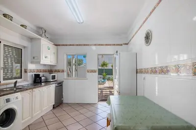a kitchen with a sink and a washing machine at Breeze Villa - Adults Only in Albufeira
