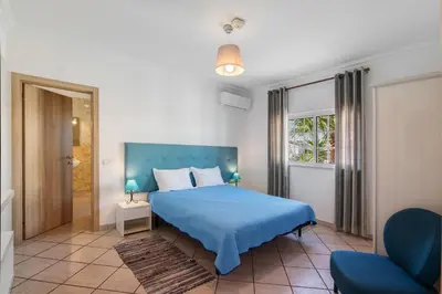 a bedroom with a blue bed with a blue blanket at Breeze Villa - Adults Only in Albufeira