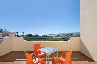 a patio with orange chairs and a table on a balcony at Breeze Villa - Adults Only in Albufeira
