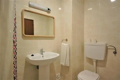 a bathroom with a sink and a toilet and a mirror at Solar dos Vilarinhos - By bedzy in Albufeira