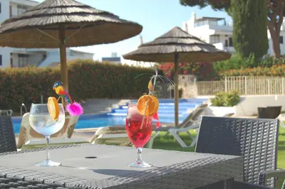 a table with two glasses on a table with umbrellas at Solar dos Vilarinhos - By bedzy in Albufeira