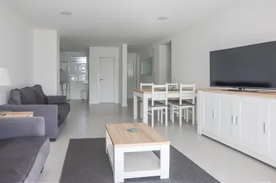 a living room with a couch and a flat screen tv at Solar dos Vilarinhos - By bedzy in Albufeira