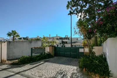a fence with a green gate in a yard at FLH Olhos D' Água Apartment with Pool in Albufeira
