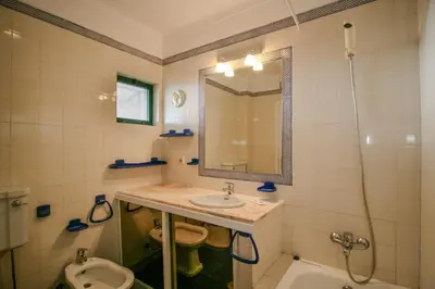 a bathroom with a sink and a toilet and a mirror at FLH Olhos D' Água Apartment with Pool in Albufeira