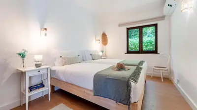 a white bedroom with a large bed and a window at Villa Casa Amendoeiras by LovelyStay in Albufeira