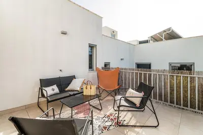 a balcony with chairs and a couch and a table at Family Villa 3 Bedrooms private rooftop with Pool in Albufeira