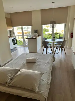 a bedroom with a large bed and a dining room at Alagoas Studio - City Center in Faro