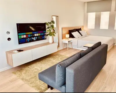 a bedroom with a bed and a couch and a tv at Alagoas Studio - City Center in Faro
