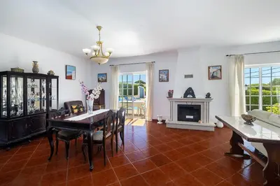 a living room with a table and a fireplace at Villa Império in Albufeira