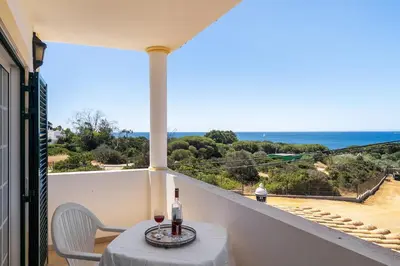 a balcony with a table and a view of the ocean at Villa Império in Albufeira