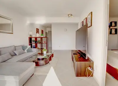 a living room with a couch and a tv at Vacation Apartment in Vilamoura in Quarteira