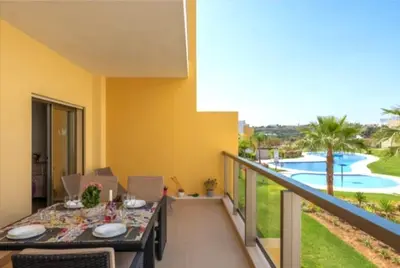 a balcony with a table and a view of a pool at Albufeira Marina Gardens AO in Albufeira