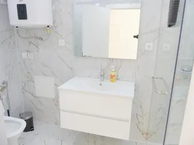 a white bathroom with a sink and a mirror at Romao Marina Vilamoura in Quarteira