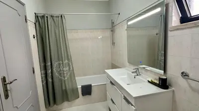 a bathroom with a sink and a shower curtain at Apartamento Flor de Amendoeira Mar in Albufeira
