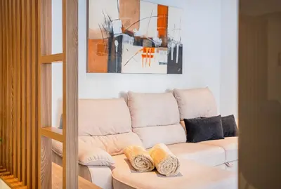 a living room with a white couch and a painting at Old Town Charm Apartment in Albufeira