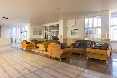 a lobby with couches and chairs and windows at 2 Bed-Sleeps 4-Vilamoura Beach-Pool-Spa-Balcony in Quarteira