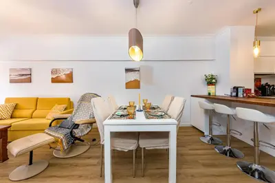 a kitchen and living room with a table and chairs at 2 Bed-Sleeps 4-Vilamoura Beach-Pool-Spa-Balcony in Quarteira
