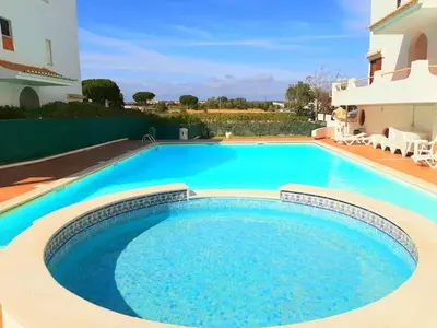 a large blue swimming pool next to a building at Sardinha Beach House in Olhos de Água