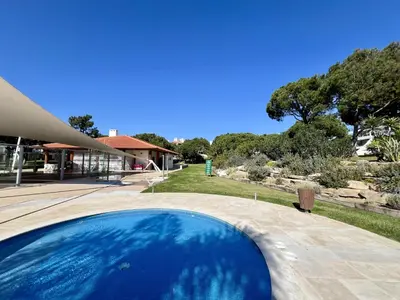 a blue swimming pool in front of a house at Vilamoura Sunny Garden With Pool by Homing in Vilamoura