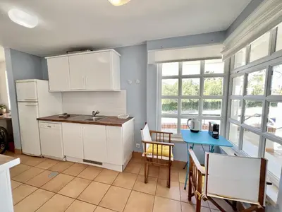 a kitchen with white cabinets and a blue table at Vilamoura Sunny Garden With Pool by Homing in Vilamoura