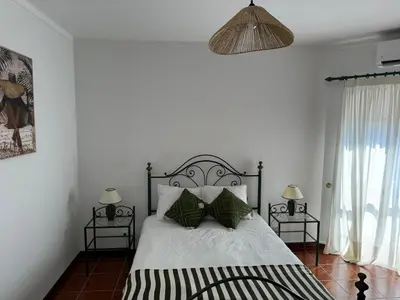 a bedroom with a black and white bed with two lamps at Apartamento Torre da Medronheira in Olhos de Água