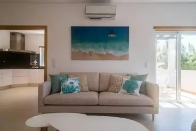 a living room with a couch with pillows at Crest 5 - 8 Pax Golf & Beach Swimming pool in Almancil