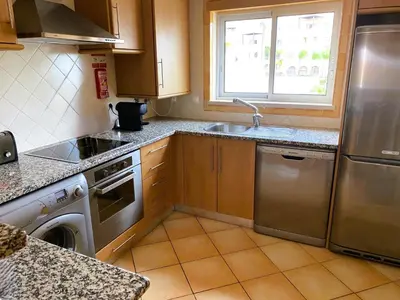 a kitchen with stainless steel appliances and a window at Old Village Prestige - Vilamoura in Vilamoura
