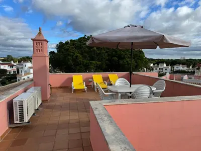 a patio with a table and chairs and an umbrella at Old Village Prestige - Vilamoura in Vilamoura