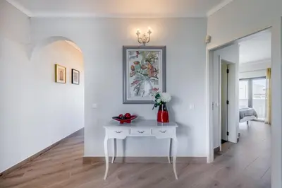 a white hallway with a white table and a painting on the wall at Casa Maré Viva in Guia