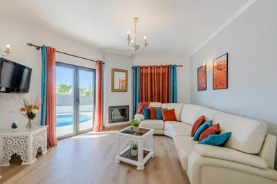 a living room with a couch and a tv at Casa Maré Viva in Guia