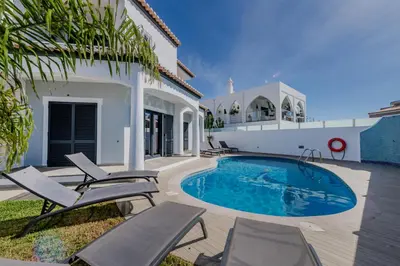a villa with a swimming pool and patio furniture at Casa Maré Viva in Guia