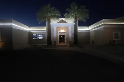 a house lit up at night with palm trees at Albufeira Lounge Hotel in Albufeira