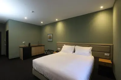 a bedroom with a large bed and a desk at Albufeira Lounge Hotel in Albufeira