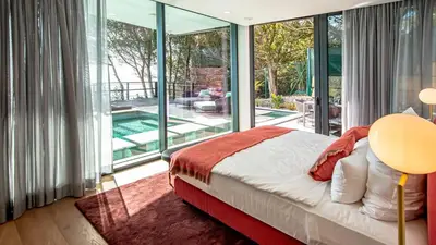 a bedroom with a bed and a balcony with a pool at Algarve Villa for Contemporary Design & Sea Views in Albufeira