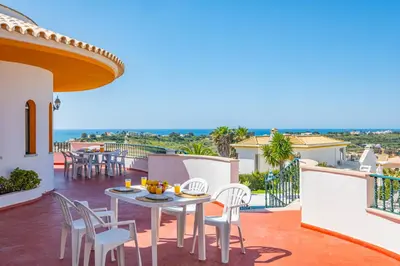 a patio with a table and chairs on a balcony at Villa Atlantida by Atlantic Places in Albufeira