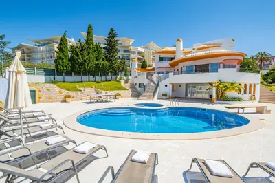 a villa with a swimming pool in front of a building at Villa Atlantida by Atlantic Places in Albufeira