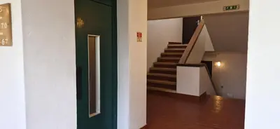 a stairway with a green door and stairs in a building at Studio on Maria Luisa Beach Wifi Parking Swimming Pool in Olhos de Água