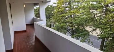 a balcony with a view of a road and trees at Studio on Maria Luisa Beach Wifi Parking Swimming Pool in Olhos de Água