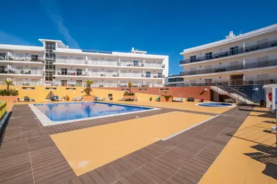 a swimming pool in front of a large building at Solarium Luxury Apartment by Atlantic Places in Albufeira
