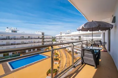 a balcony with an umbrella and a swimming pool at Solarium Luxury Apartment by Atlantic Places in Albufeira