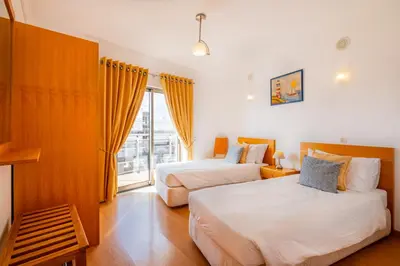 a hotel room with two beds and a window at Solarium Luxury Apartment by Atlantic Places in Albufeira