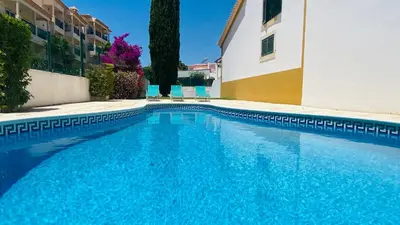 a large blue swimming pool next to a building at Noly by Check-in Portugal in Albufeira