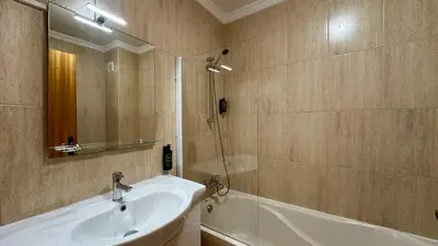 a bathroom with a sink and a tub and a mirror at Noly by Check-in Portugal in Albufeira
