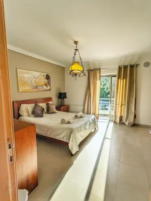 a bedroom with a bed and a chandelier at Villa Quintaloes, 5 mins from Old Town Albufeira in Albufeira