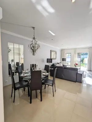 a dining room and living room with a table and chairs at Villa Quintaloes, 5 mins from Old Town Albufeira in Albufeira