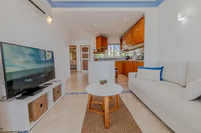 a living room with a white couch and a tv at Ocean Vista Retreat with Beach & Pool Access by Drago Rentals in Albufeira