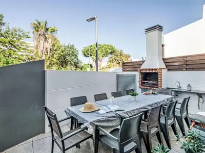 a patio with a table and chairs and a fireplace at Holiday Home Praia V5 VIP Properties by Interhome in Vilamoura