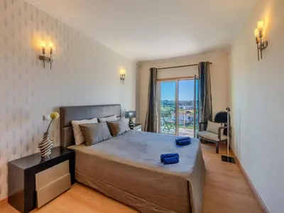 a bedroom with a large bed and a large window at Holiday Home Encosta dos Salgados by Interhome in Galé